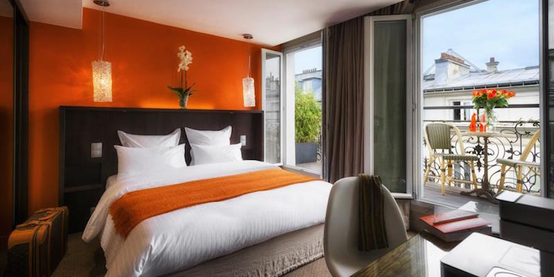 A lovely hotel room in Paris with orange accents