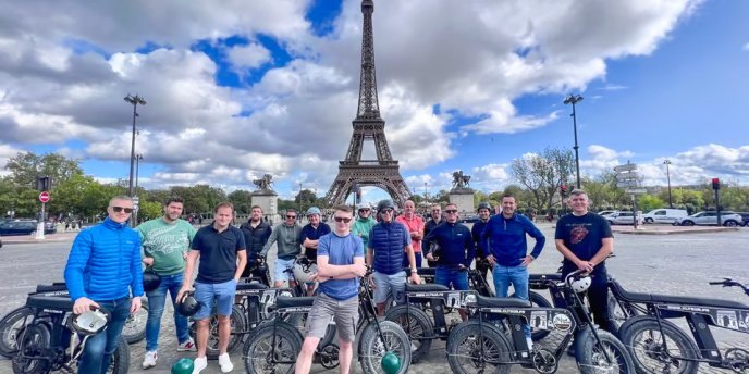 Cyclist pose in front of the Eiffel Tower during a Guided Tour of Paris on an Electric Bike