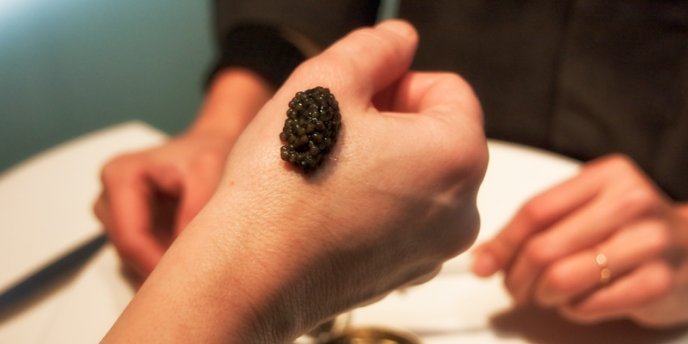 The proper way to sample Caviar, a dollop on the side of a hand