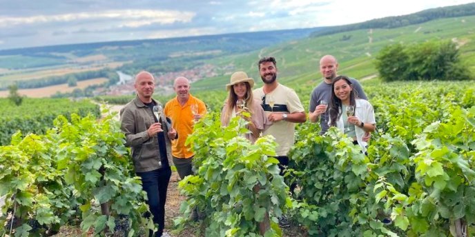 A happy group in a vineyard during a Champagne tour and tasting