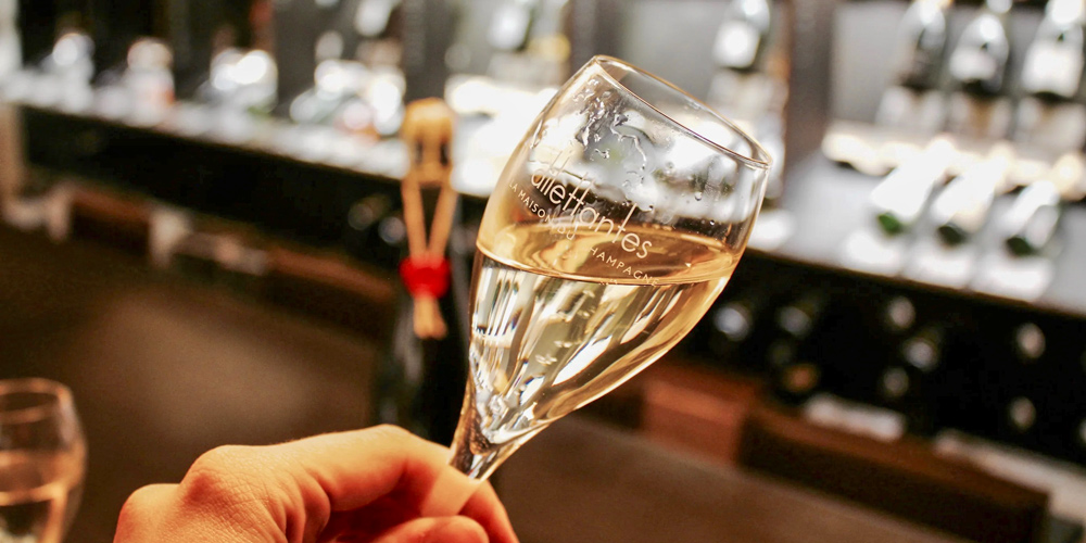 A hand holding a glass of champagne at Dilettantes