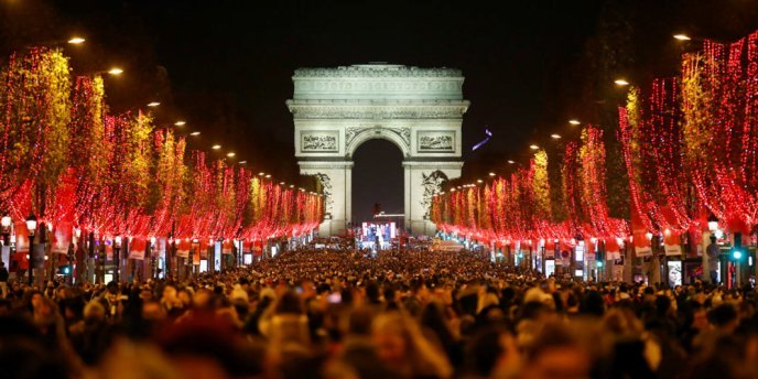 Night view of the red-themed Christmas lights along the Champs-ELysees in Paris with the Arc de Triomphe in the background