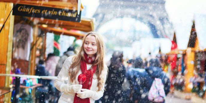 A young woman with a candy apple at a Christmas market in Paris