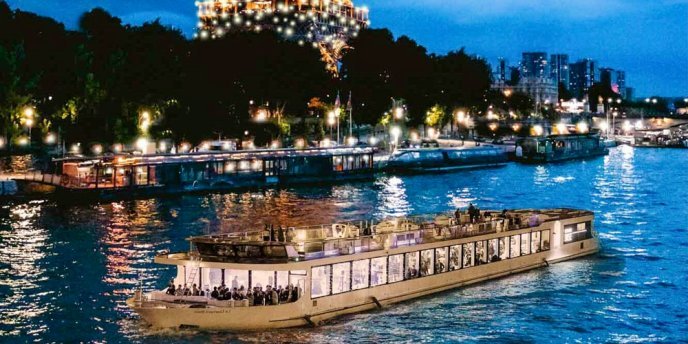 Bateau Diamant Bleu dinner cruise sailing on the Seine River at night with illuminated Paris skyline