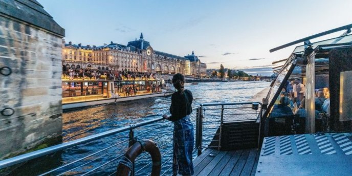 Woman enjoying a Paris dinner cruise on the Seine River with stunning views of the Eiffel Tower