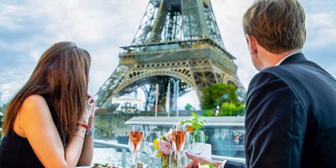 A couple gaze at the Eiffel Tower during a Seine River Gourmet Lunch