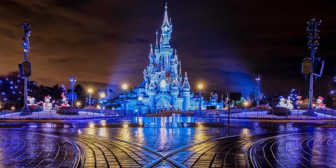 The Magic Castle at Disneyland Paris lit a night with blue lights