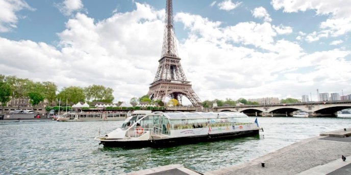 IN Paris a river boat cruises along the Seine beneath the Eiffel Tower