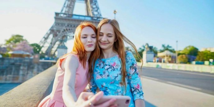 Two young women takinga selfie at the Eiffel Tower