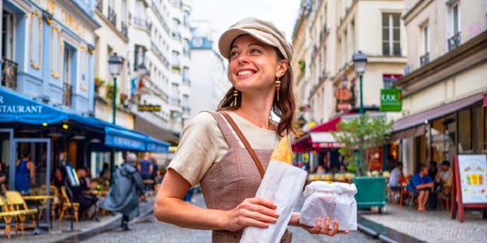 A young woman in the Marais carryig a fresh baguette