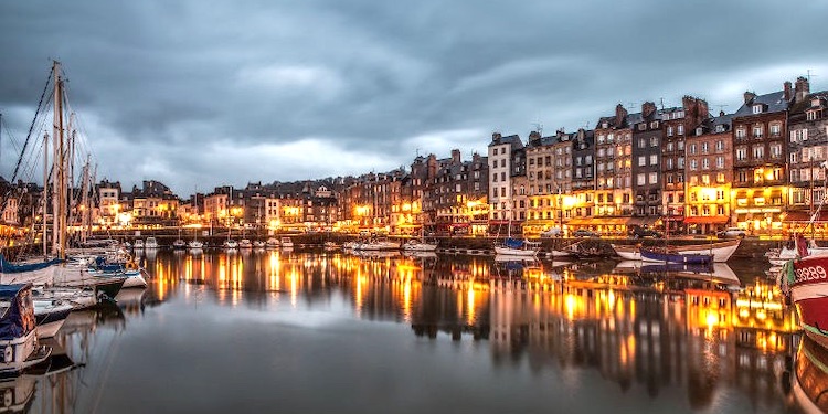 Nighttime view of the harbor at Honfleur with glowing lights