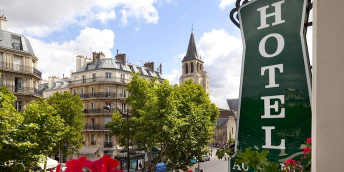 In the 6th Arrondissement a hotel sign with the tower of Saint Germain in the distance