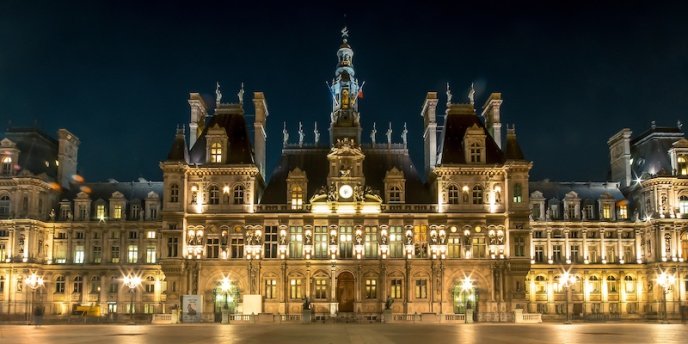 The grand facade of the Hotel de Ville in Paris lit at night