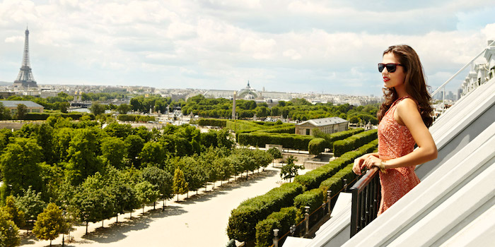 A woman guests gazes from her room at Hotel Meurice at the gardens and the Eiffel Tower