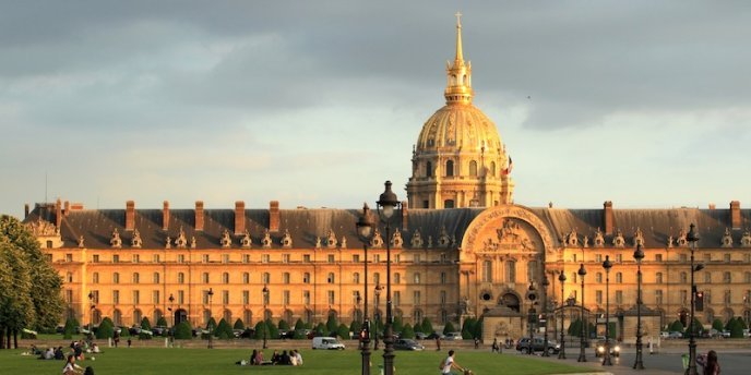 A golden sunset view of Les Invalides in Paris, with the dome of the Tomb of Napoleon in the background