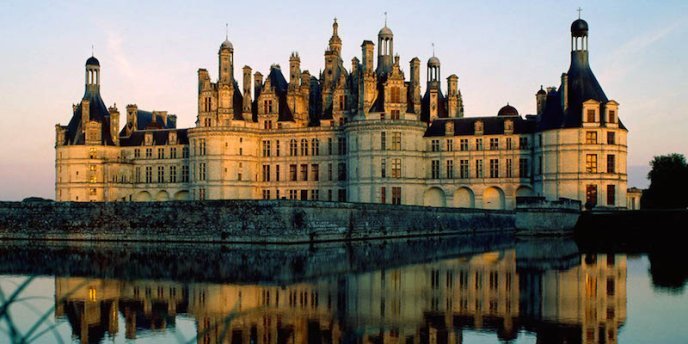 A chateau in the Loire Valley at suent, reflected in a pond