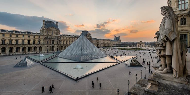 The Louvre courtyard at sunset, with the pyramid in the foreground