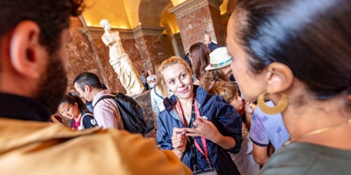 A tour guide explains the artwork at the Louvre during a Skip the Lines tour