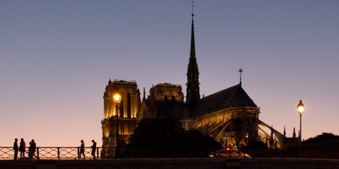 Notre Dame at night, with people on Pont des Arts, Photo by Mark Craft