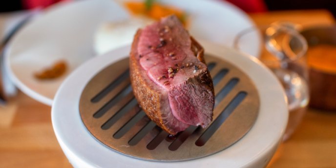 A slice of duck breast served on a mini smoker at Restaurant Escudella