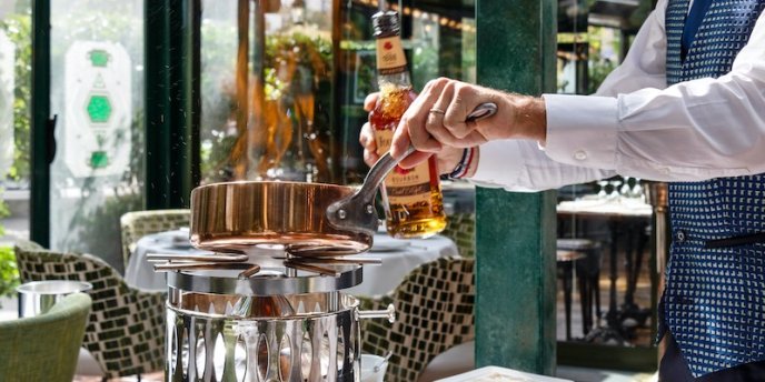 A server prepares a dish at the table at La Closerie des Lilas