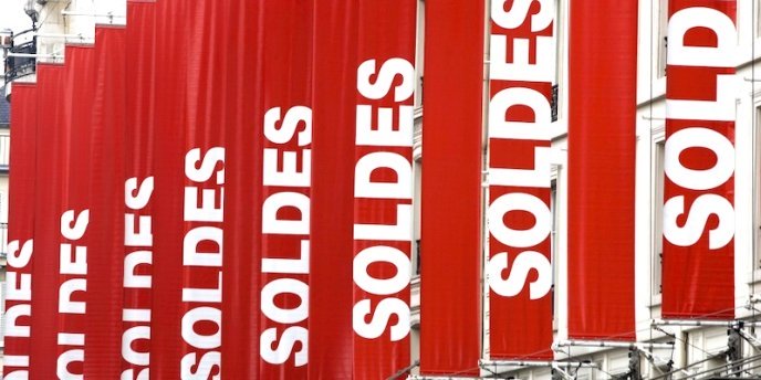 Red banners announcing the annual sales at a Paris department store