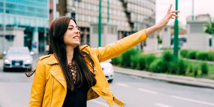 Woman hailing a taxi at the airport