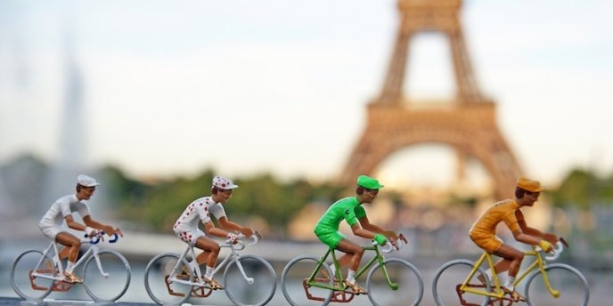 Figures of Tour de France racers posed in front of the Eiffel Tower