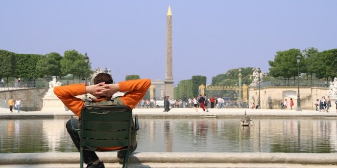 A man relaxing next to the pond in Jardin des Tuileries in Paris