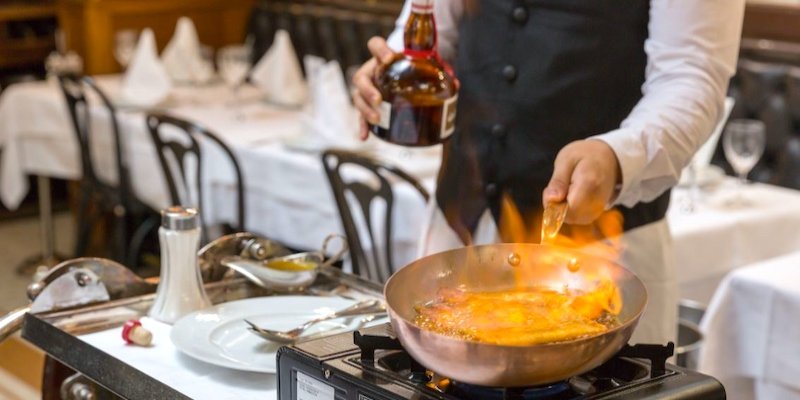 Waiter preparing a dish table side at one of the Historic Brasseries of Paris