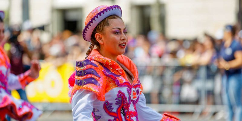 Carnaval de Paris Grand Parade participant in custom-made costume in orange and white