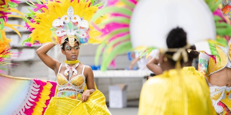 Participants wear colorful yellow costumes in the Grand Parade