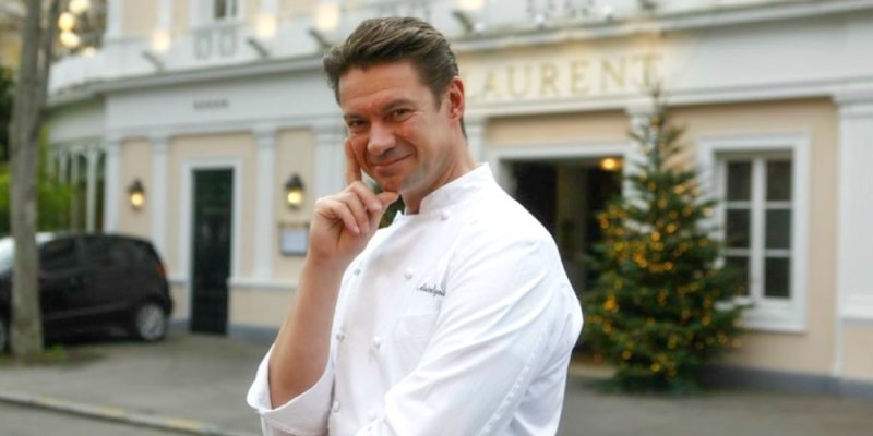 Chef Alain Pégouret posing in front of restaurant Laurent Paris