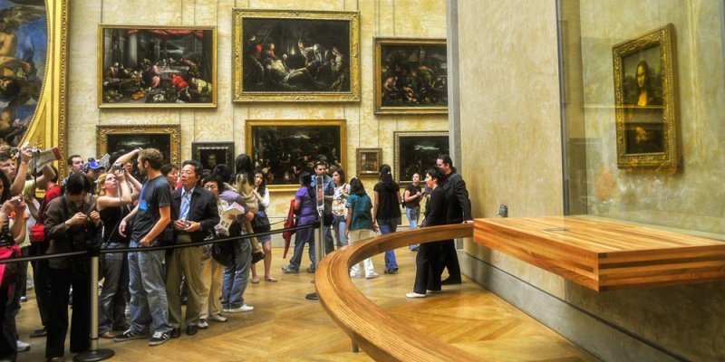 The Mona Lisa, protected from the crowd of viewers by a wooden barrier and velvet ropes