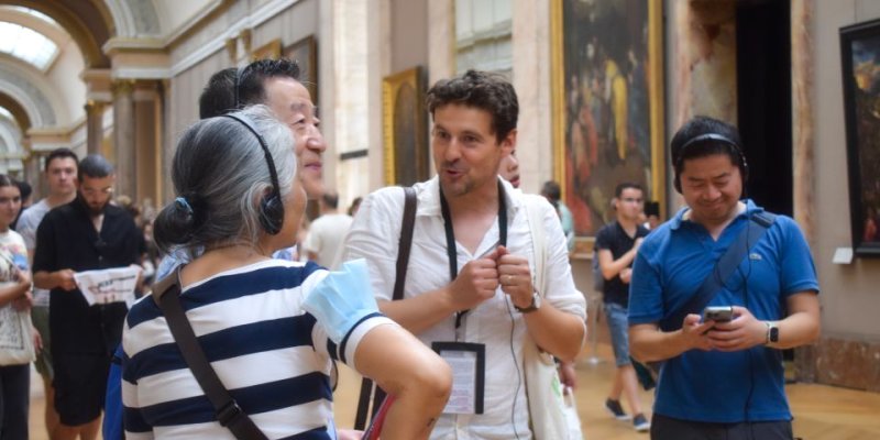 At the Louvre an art expert explains the painting to his tour group