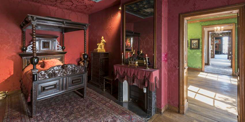 The author's bedroom, with a four-posted bed and a view through the other rooms. 