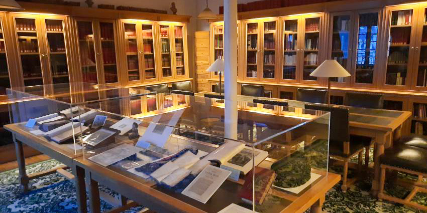 The library at the Maison, display books in glass cases