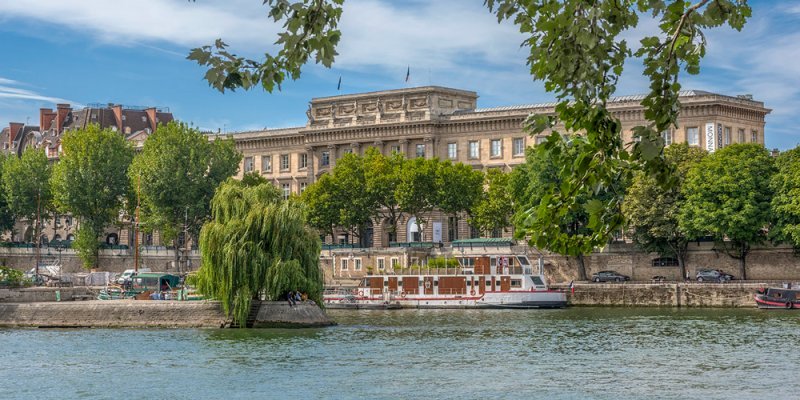 Monnaie de Paris seen from the Seine with boats docked in front