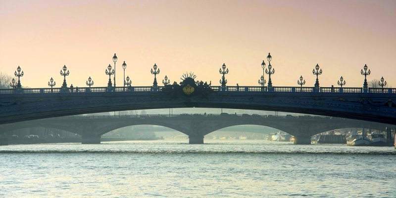 Pont Alexandre III Paris seen from the Seine at a pink sky sunset, with details of the lampposts clearly shown