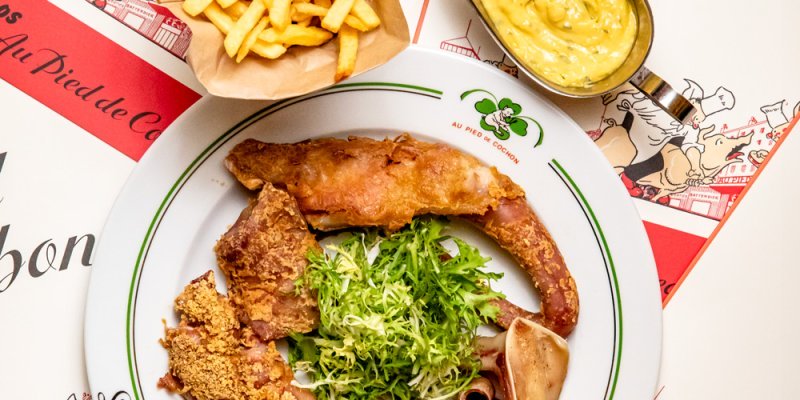 A plate of food at Au Pied de Cochon featuring fries and sauce