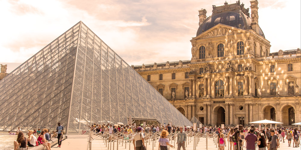 The courtyard and pyramids of the Louvre with a golden reflection