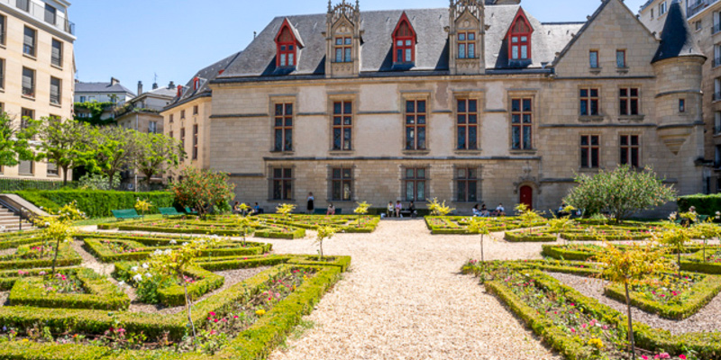 In the garden of Hotel de Sens with the medieval facade flanking the plantings